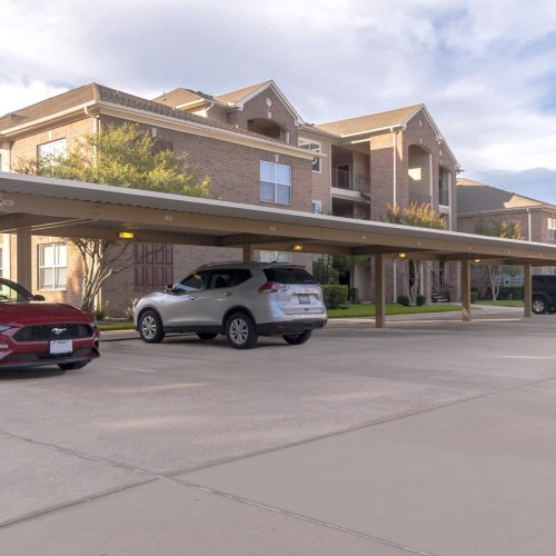 Find your perfect fit at Heritage at Hooper Hill Apartments a parking lot with cars and a building in the background